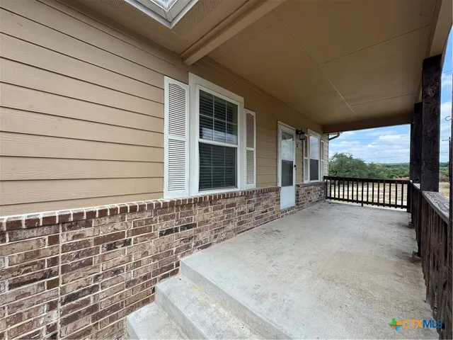 a view of kitchen with refrigerator and windows
