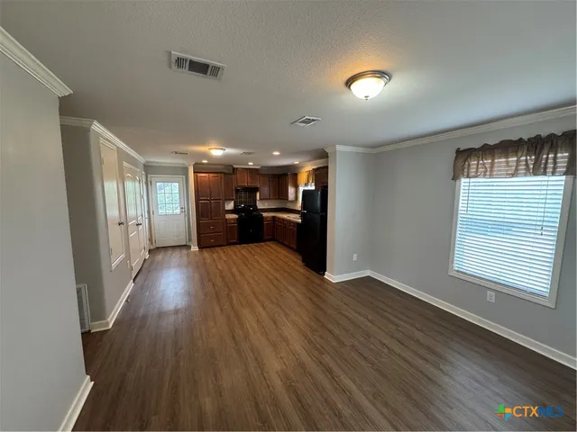 a view of empty room with wooden floor