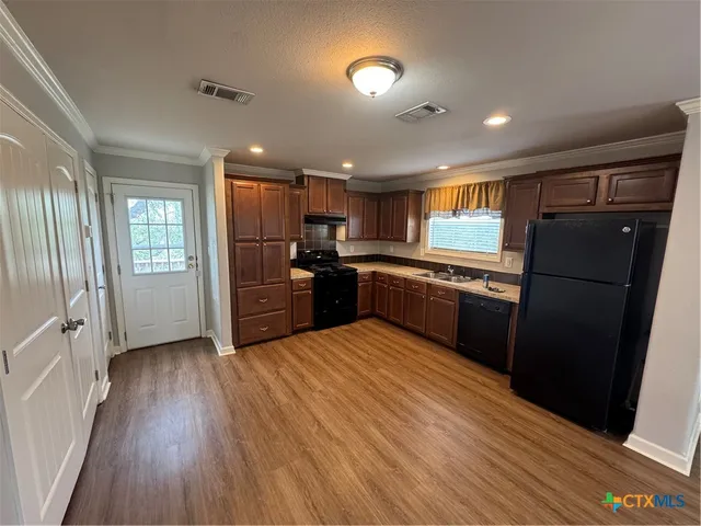 a kitchen with stainless steel appliances granite countertop a refrigerator and a stove