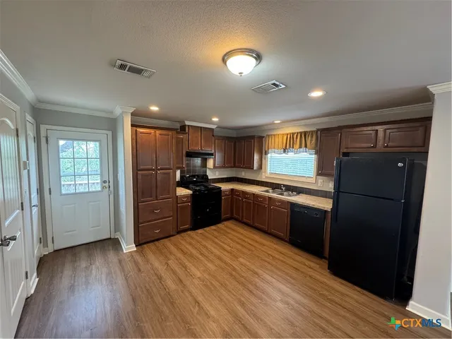 a modern kitchen with stainless steel appliances granite countertop a refrigerator and a stove