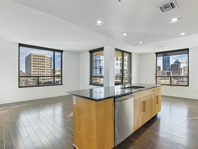 a large kitchen with stainless steel appliances granite countertop a stove and a large window