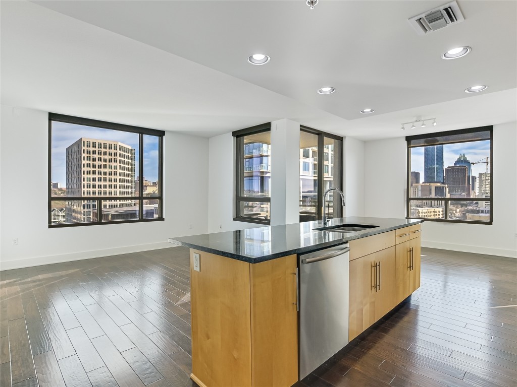 a large kitchen with stainless steel appliances granite countertop a stove and a large window