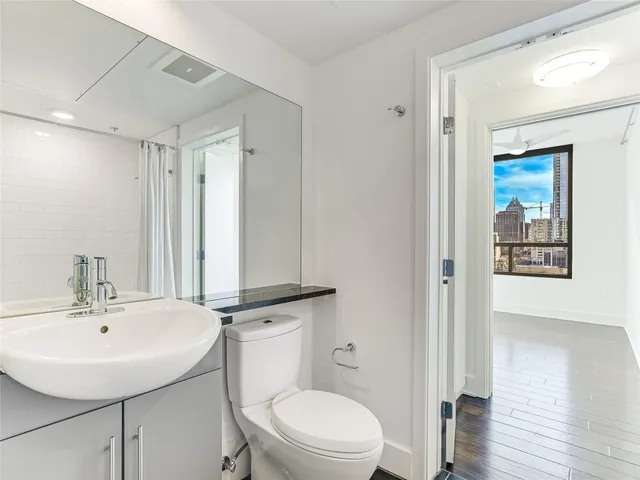a bathroom with a toilet a sink and mirror