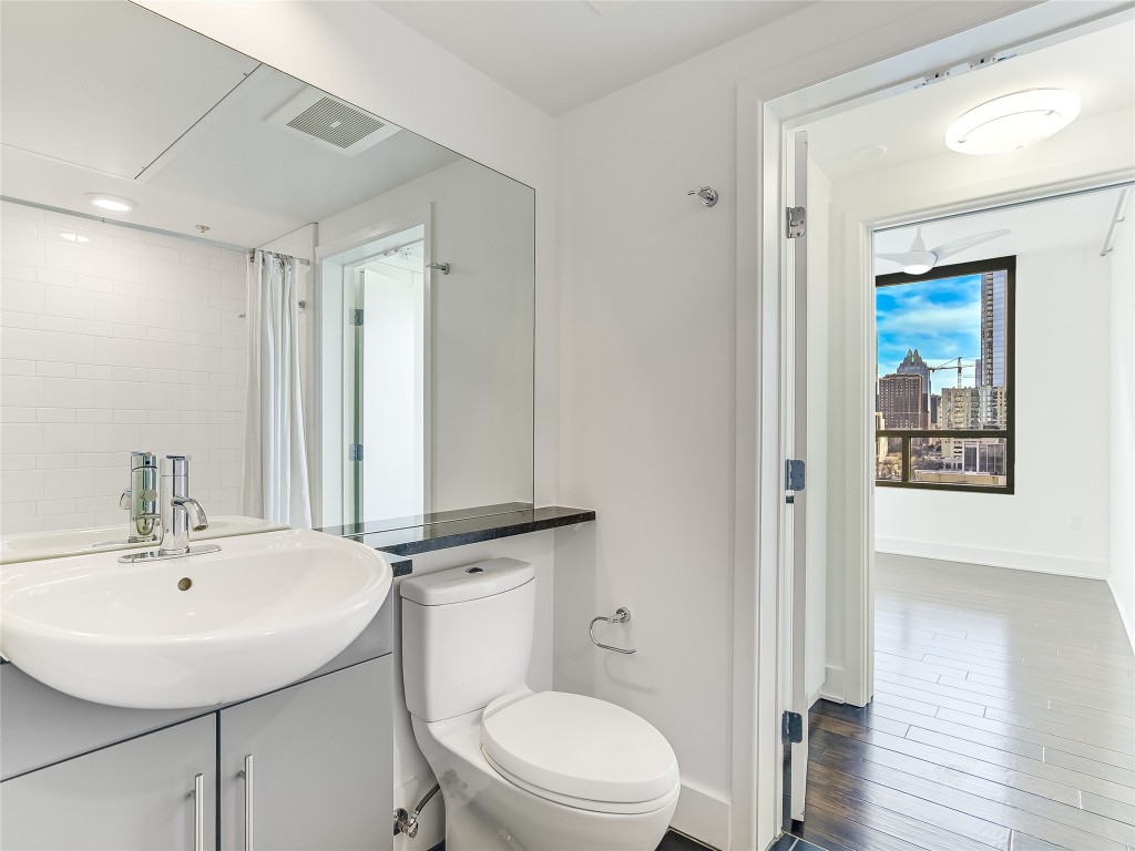 300 Bowie Street, Unit 1001 Austin, TX 78703 - Photo 11 of 18 a bathroom with a toilet a sink and mirror
