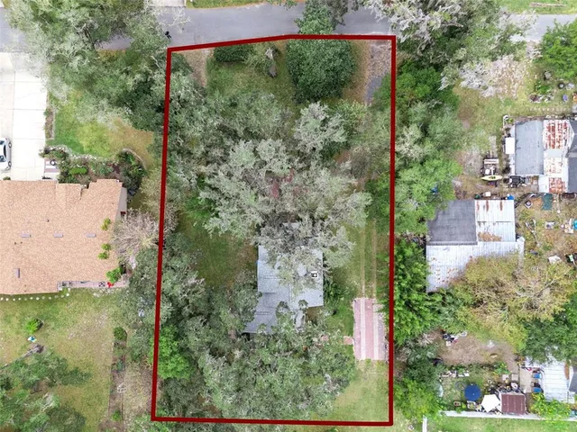 an aerial view of a houses with a yard and lake view