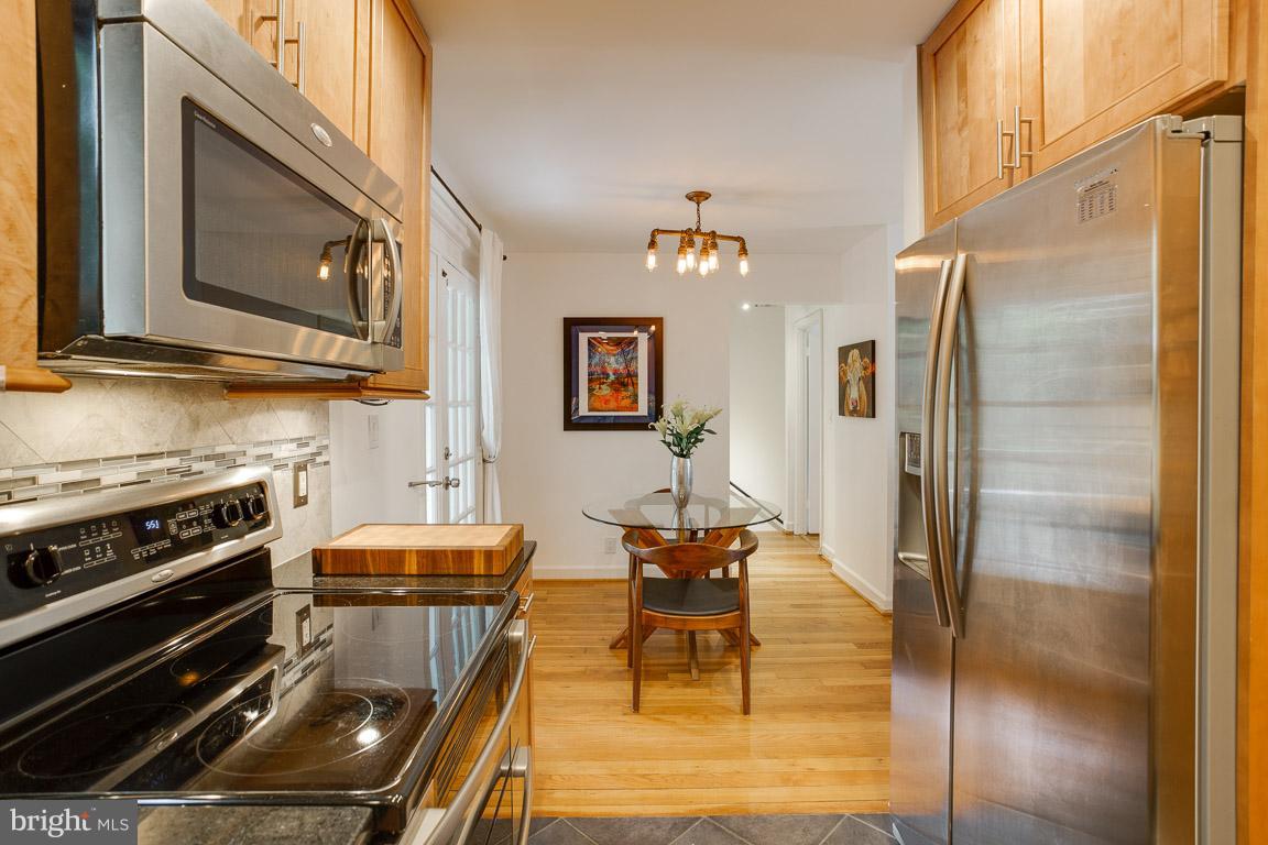 4914 29th Road South, Unit A2 Arlington, VA 22206 - Photo 5 of 30 a kitchen with stainless steel appliances kitchen island granite countertop a stove top oven a sink and a refrigerator