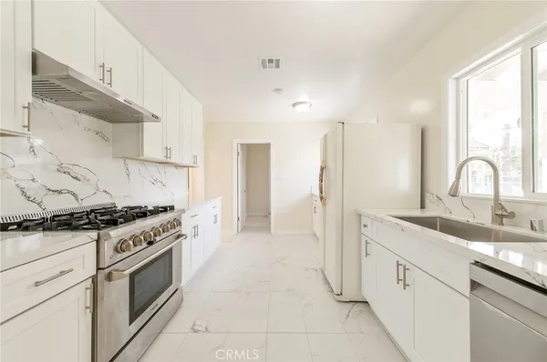 a kitchen with stainless steel appliances granite countertop a stove and a sink