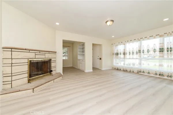 a view of an empty room with a fireplace and a window