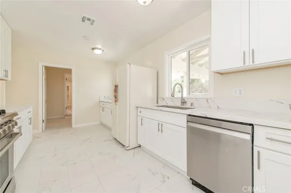 a kitchen with granite countertop white cabinets and white appliances