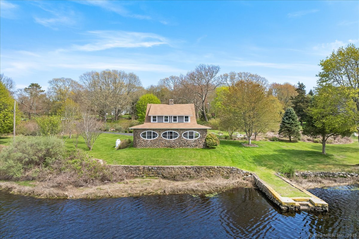 a view of a park with large trees and a wooden fence
