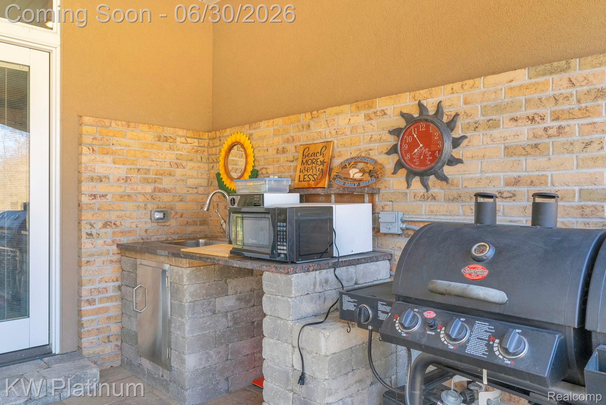 2235 South Lake Shore Road Harbor Beach, MI 48441 - Photo 55 of 99 Outdoor kitchen area featuring light-colored brick veneer, paver flooring, a built-in stainless steel sink, and a built-in refrigerator