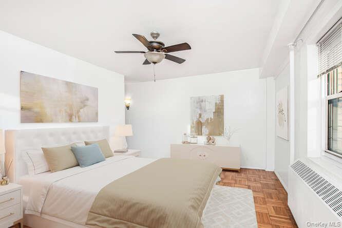 6 Fordham Hill Ovl, Unit 15F Bronx, NY 10468 - Photo 19 of 26 Virtually staged Primary Bedroom with radiator and a ceiling fan