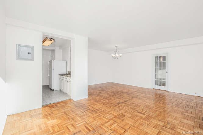6 Fordham Hill Ovl, Unit 15F Bronx, NY 10468 - Photo 9 of 26 Living room and dining area with a chandelier