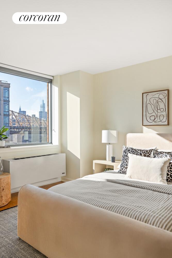 425 Main Street, Unit 15E Manhattan, NY 10044 - Photo 6 of 30 a bedroom with a large bed and a large window