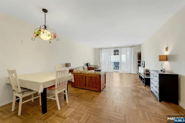 a dining room with wooden floor a chandelier a wooden table and chairs