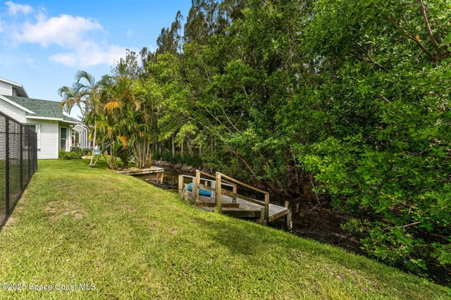 an aerial view of a residential houses with yard