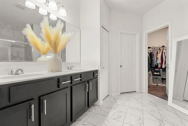 a bathroom with a double vanity sink a mirror and a shower