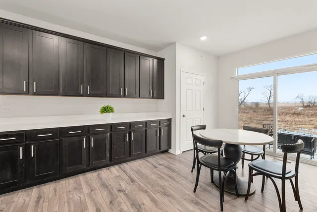 a kitchen with a table chairs and wooden cabinets