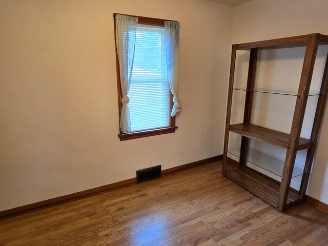 an empty room with wooden floor and entrance