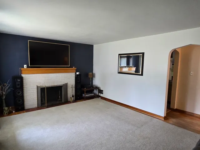 an empty room with windows and fireplace
