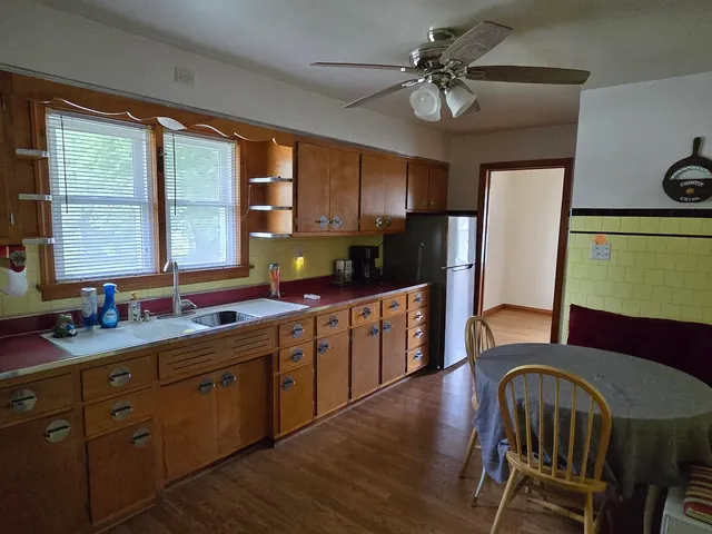 a kitchen with stainless steel appliances granite countertop a sink a stove a refrigerator cabinets and dining table