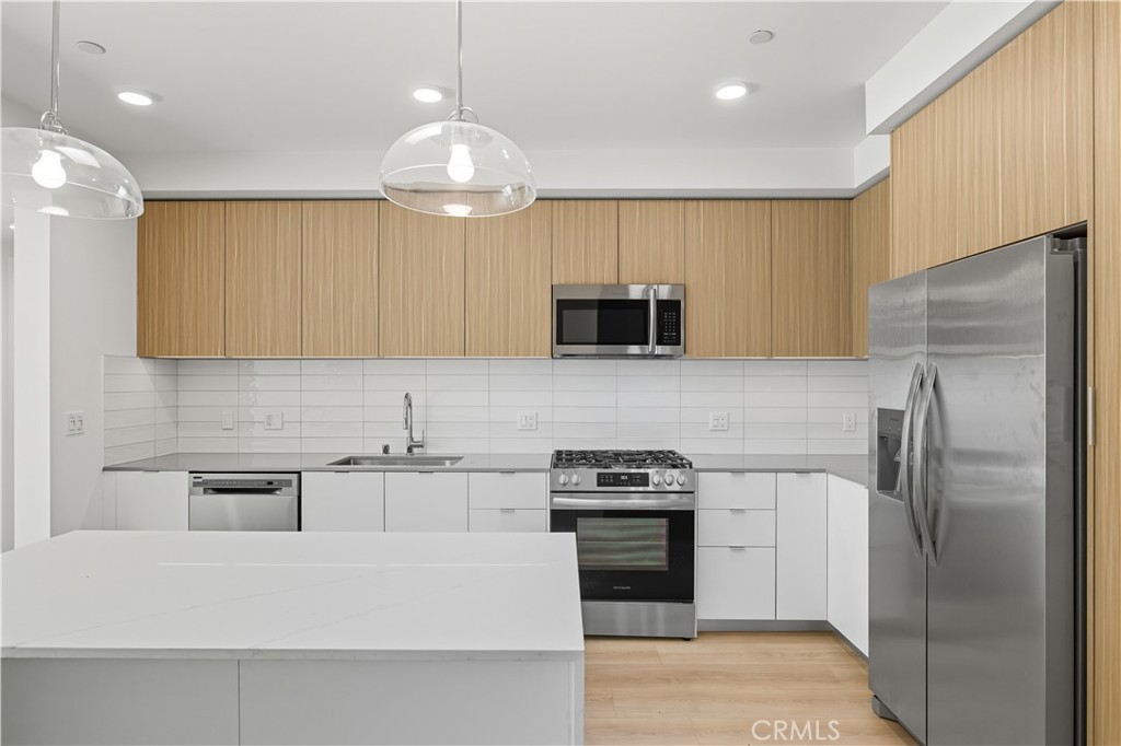 12078 Guerin Street, Unit 103 Studio City, CA 91604 - Photo 1 of 7 a kitchen with kitchen island stainless steel appliances a sink cabinets and a counter top space