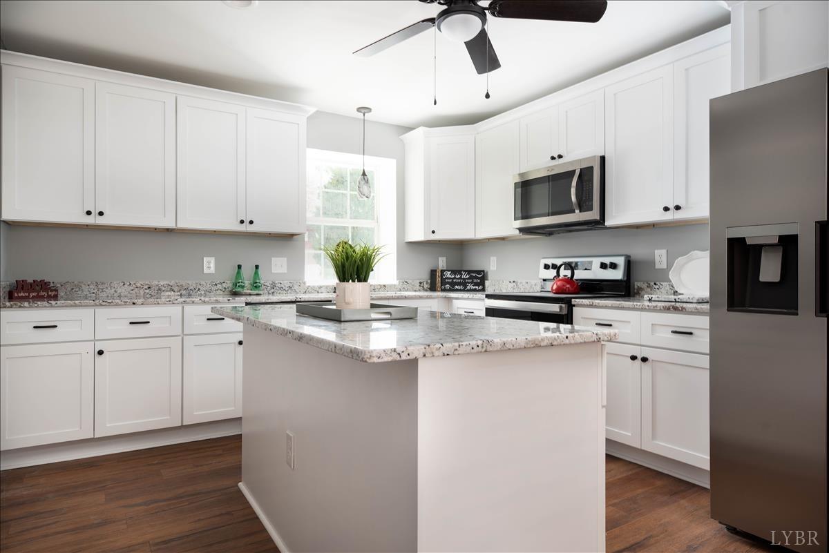 132 Spring Street Madison Heights, VA 24572 - Photo 12 of 63 a kitchen with stainless steel appliances granite countertop a sink a stove a refrigerator and cabinets with wooden floor