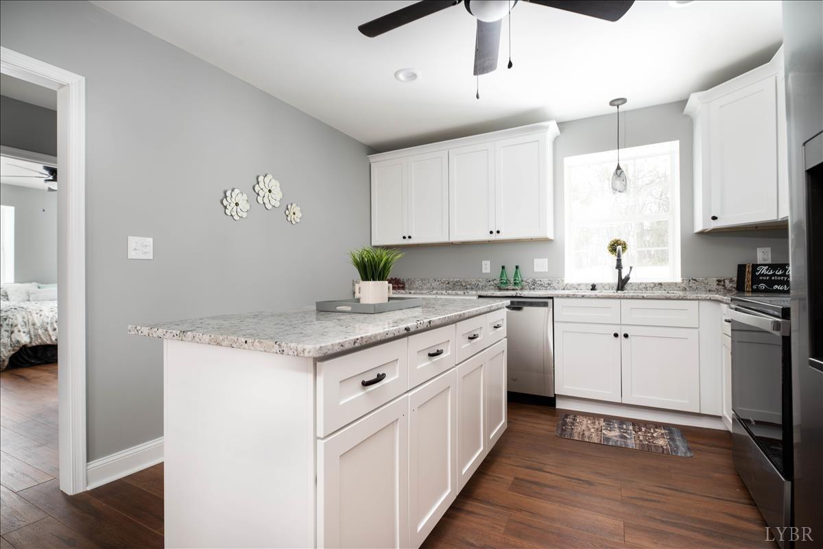 132 Spring Street Madison Heights, VA 24572 - Photo 19 of 63 a kitchen with granite countertop a sink appliances cabinets and wooden floor
