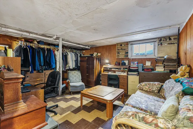a living room with furniture a rug and kitchen view