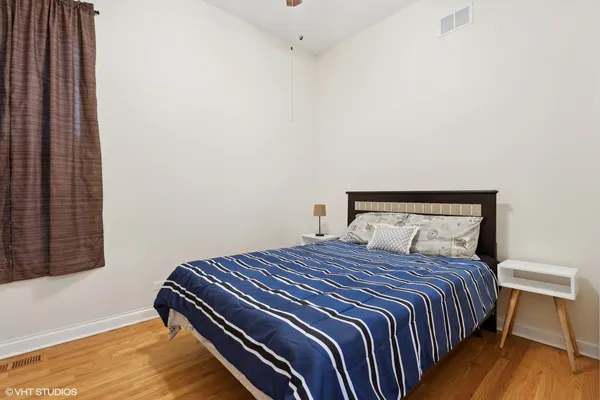 a bedroom with a bed and wooden floor