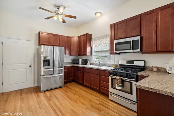 a kitchen with granite countertop a refrigerator a stove top oven a sink and dishwasher