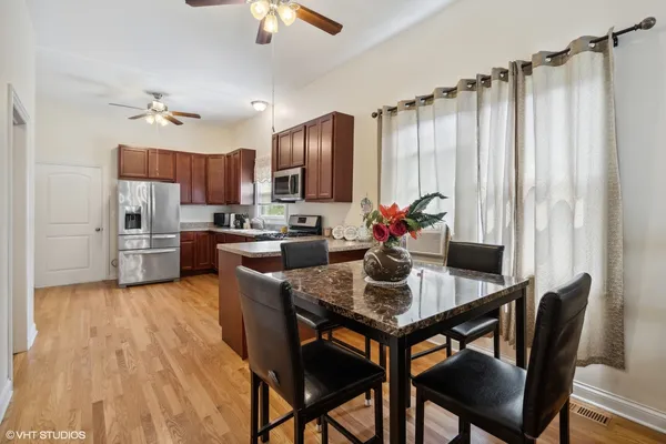 a kitchen with a table chairs refrigerator and microwave