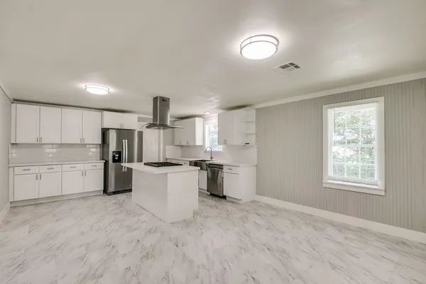 a kitchen with white cabinets and appliances