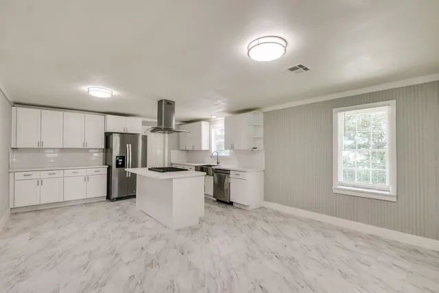 a kitchen with white cabinets and appliances