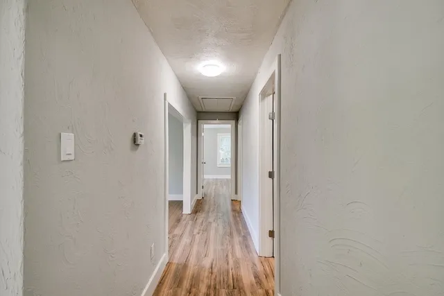 a view of a hallway with wooden floor
