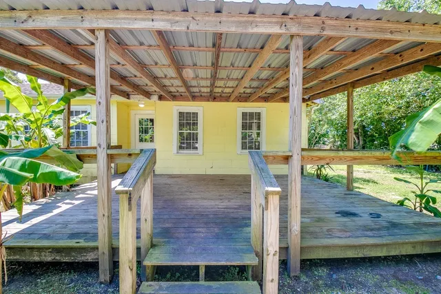 a front view of a house with wooden floor and outdoor seating