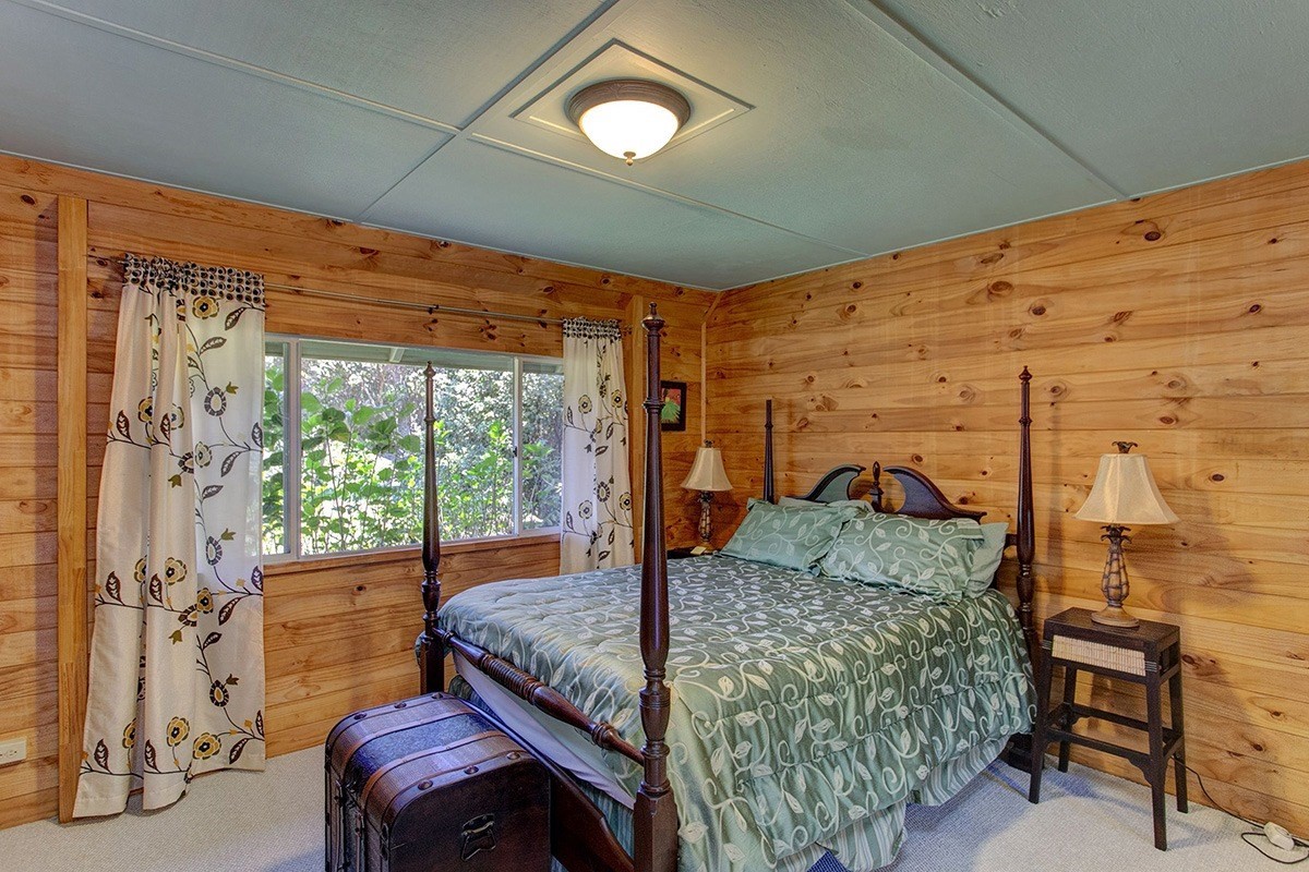 99-7721 Kilau Place Volcano, HI 96785 - Photo 11 of 26 a bedroom with a bed and a table