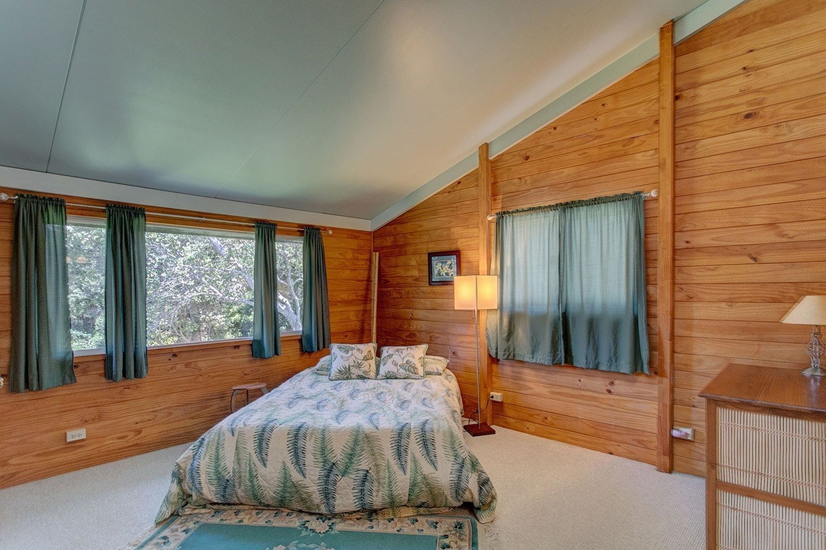 99-7721 Kilau Place Volcano, HI 96785 - Photo 15 of 26 a bedroom with a large bed and two large window