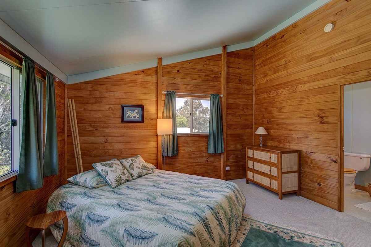 99-7721 Kilau Place Volcano, HI 96785 - Photo 16 of 26 a bedroom with a bed and a flat screen tv