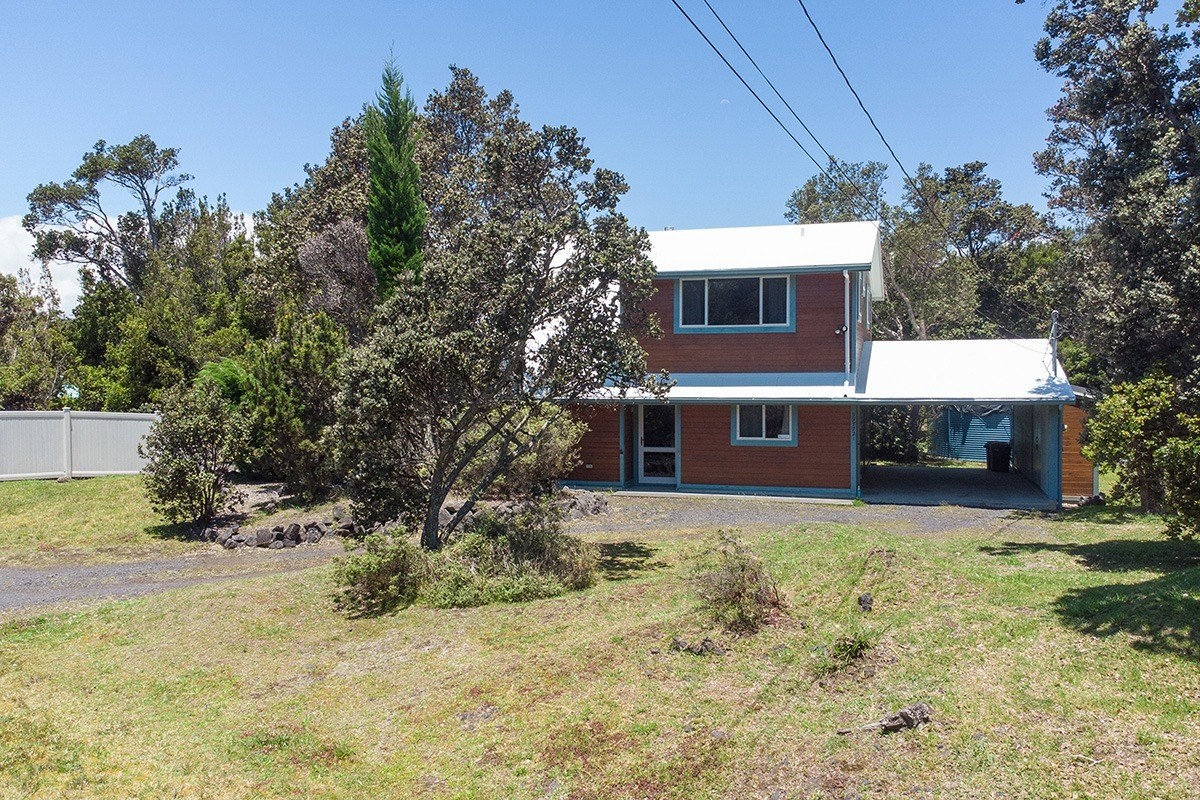 99-7721 Kilau Place Volcano, HI 96785 - Photo 24 of 26 a front view of house with yard and trees in the background