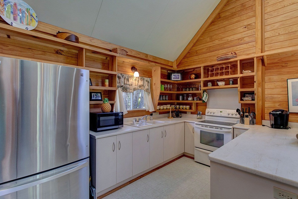 99-7721 Kilau Place Volcano, HI 96785 - Photo 4 of 26 a kitchen with stainless steel appliances a stove and a refrigerator
