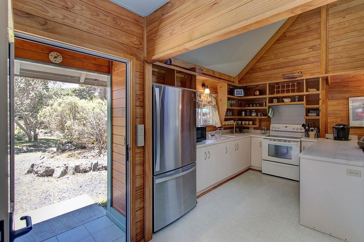 99-7721 Kilau Place Volcano, HI 96785 - Photo 5 of 26 a kitchen with white cabinets and white appliances