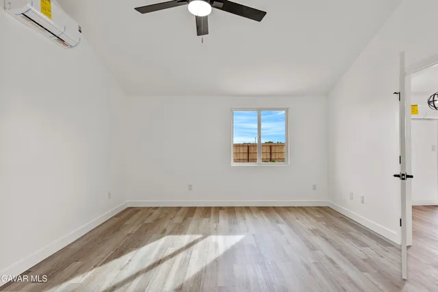 an empty room with a window and wooden floor