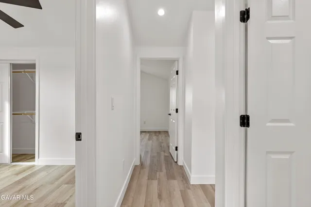 a view of a hallway with wooden floor