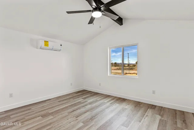 an empty room with a window and ceiling fan