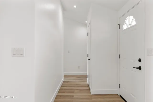 a view of a hallway with wooden floor