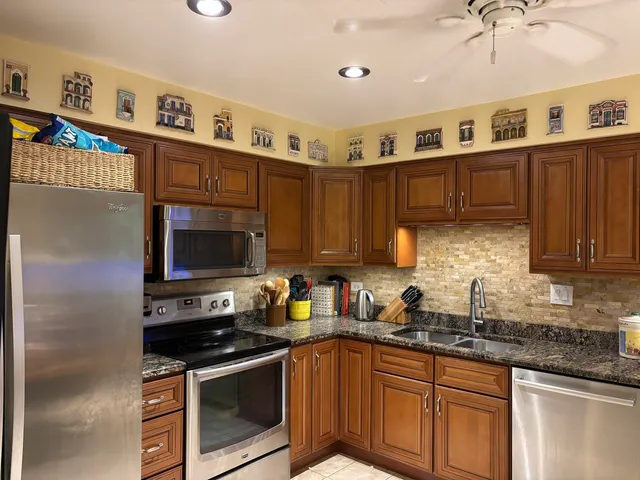 a kitchen with stainless steel appliances granite countertop a sink stove microwave and cabinets