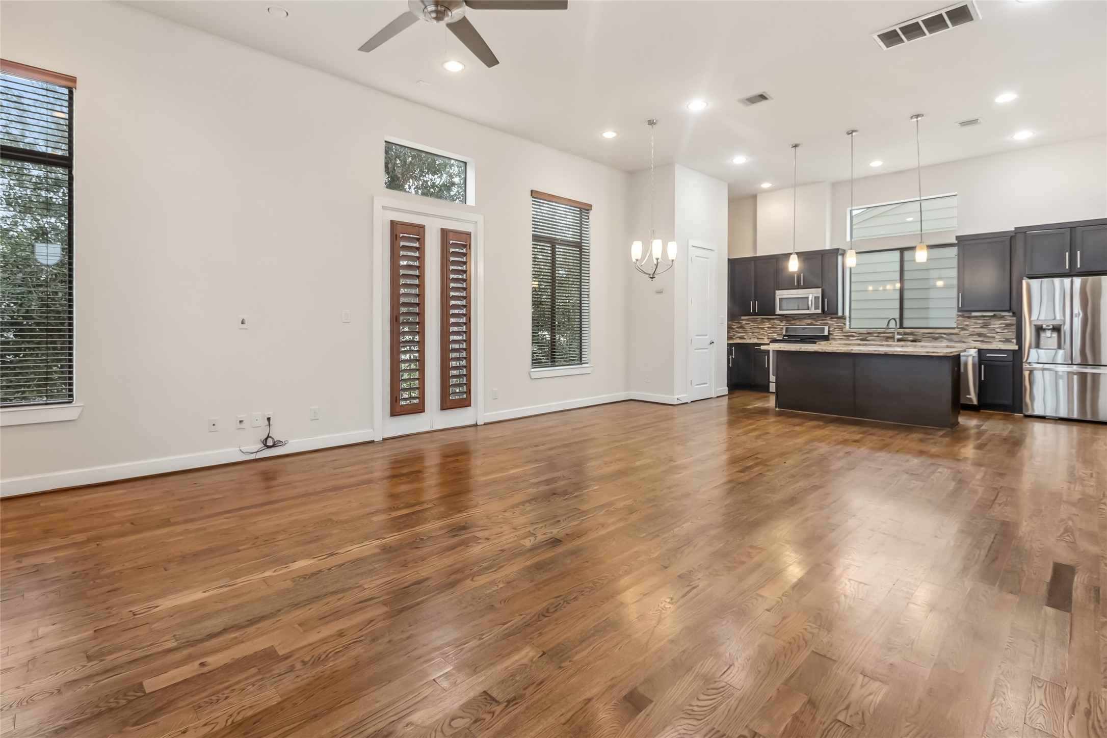 5729 Larkin Street, Unit A Houston, TX 77007 - Photo 5 of 23 a view of a kitchen with kitchen island granite countertop wooden floor stainless steel appliances and windows