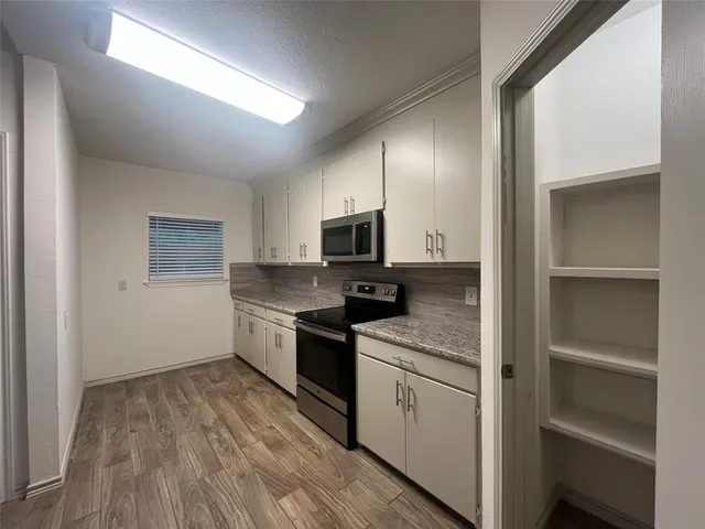 a kitchen with a sink microwave and cabinets