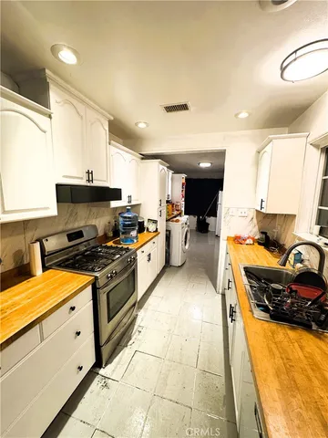 a kitchen with stainless steel appliances granite countertop a sink stove and cabinets